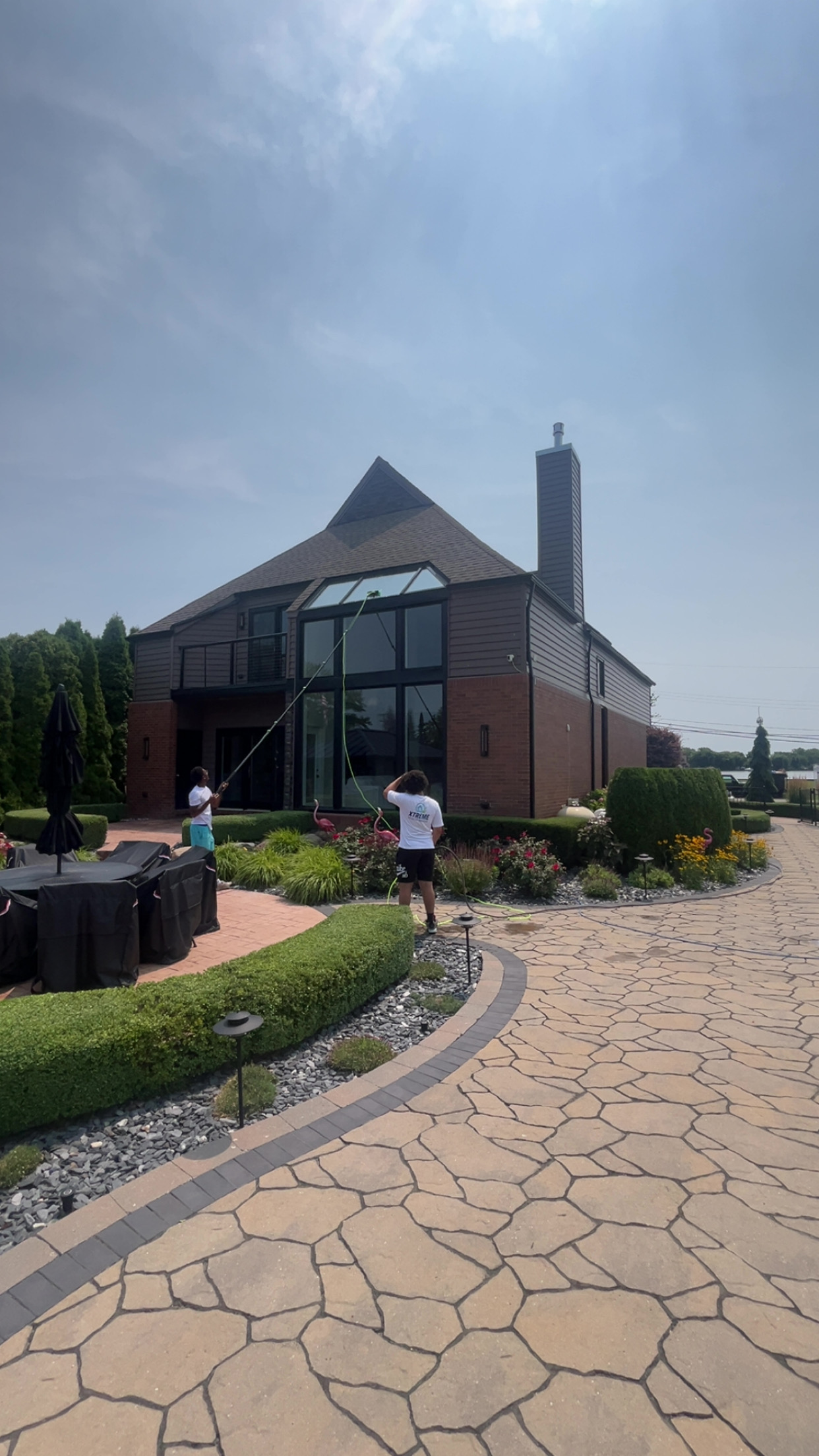 Xtreme crew cleaning windows on luxury stone driveway home