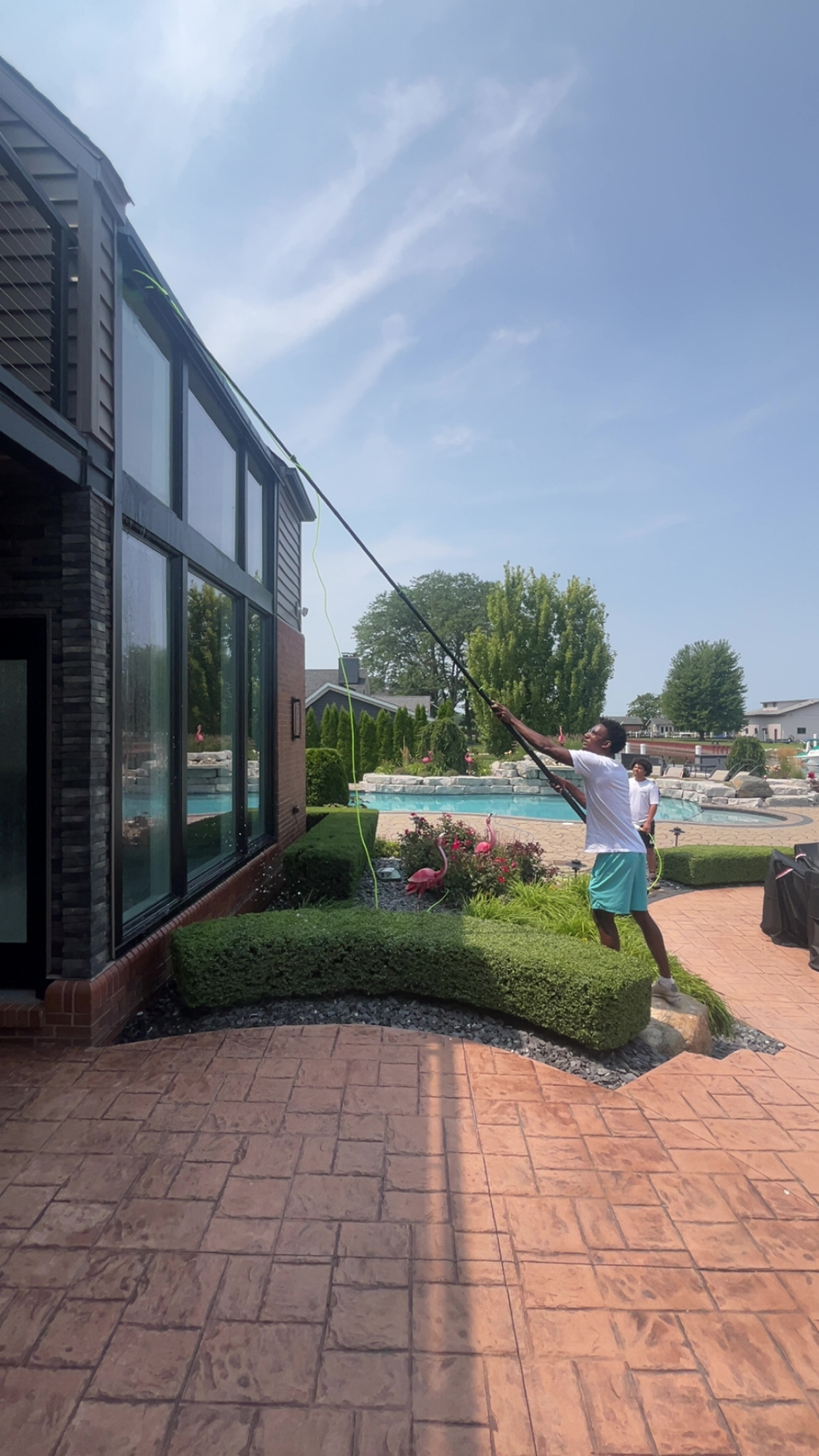Window cleaning on modern glass home with pool